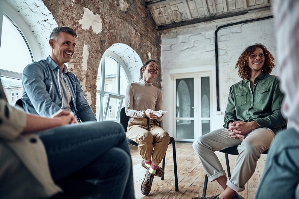 Group therapy session sitting in a circle and laugh